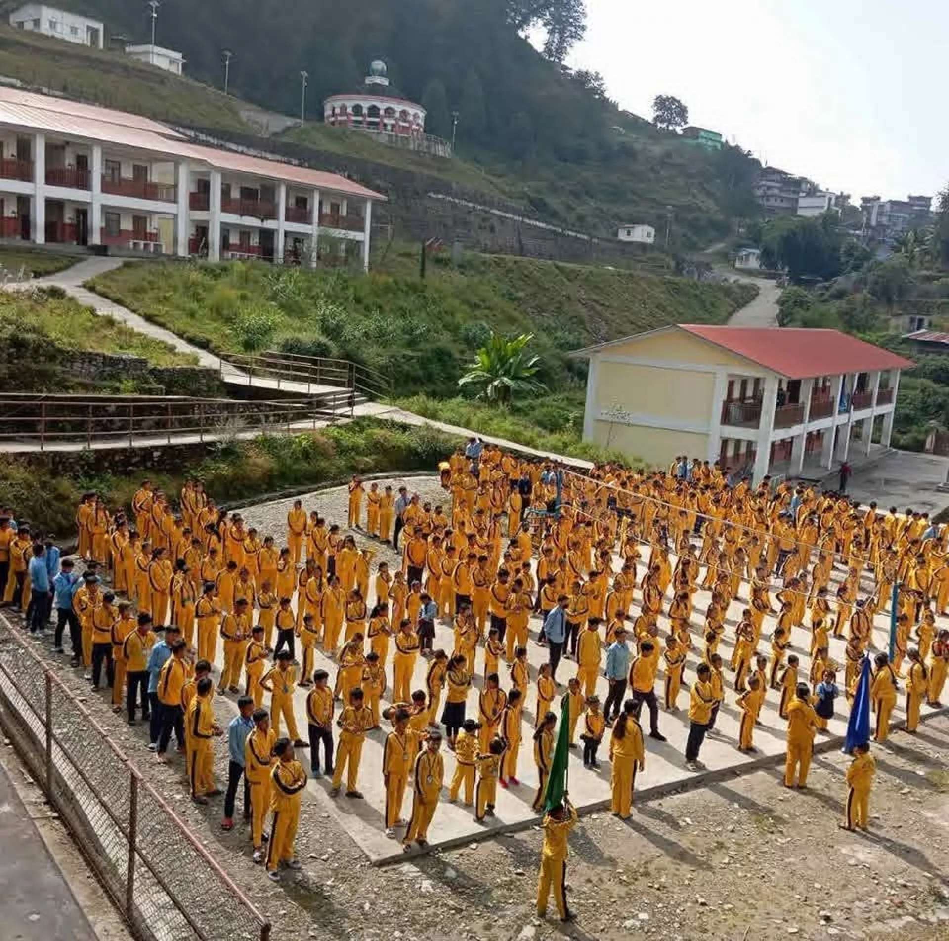 Students gathered in the school courtyard with mountain views